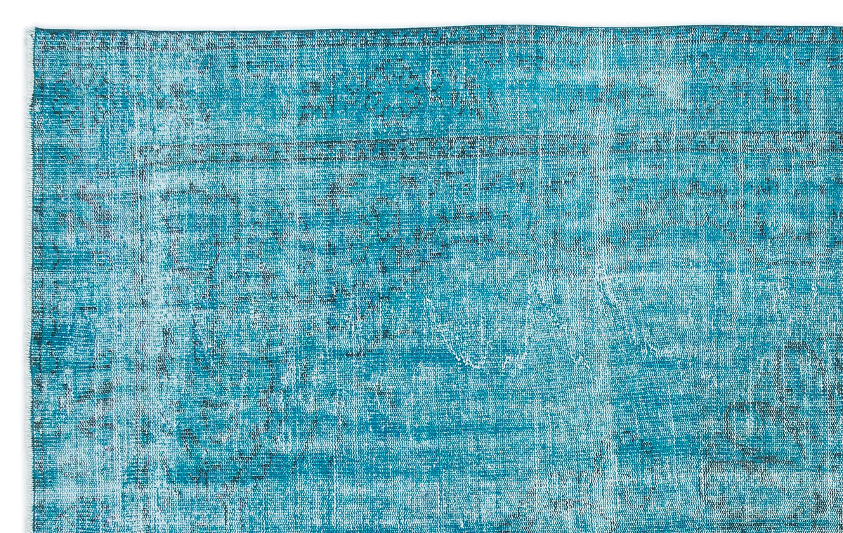 Teal and white distressed rug with a faded traditional medallion pattern.