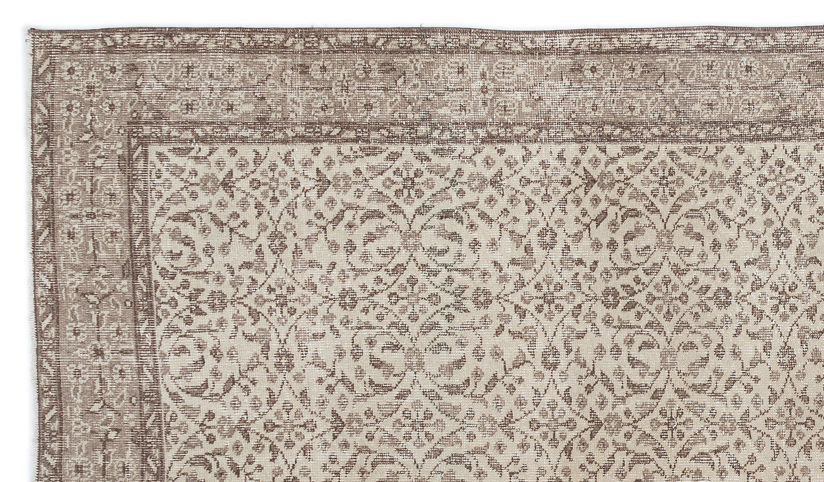 Taupe and cream rug with a distressed traditional floral medallion pattern and a wide decorative border.