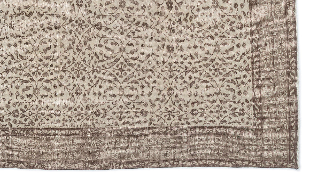 Beige and brown rug with a repeating floral medallion pattern and a wide, detailed border.