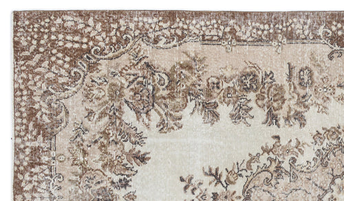 Load image 1 in gallery view. Distressed brown and beige rug with a traditional floral medallion pattern and ornate border.