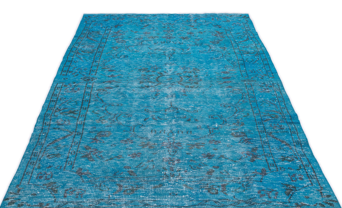 Bright blue distressed area rug with a faded traditional medallion pattern and dark grey border details.