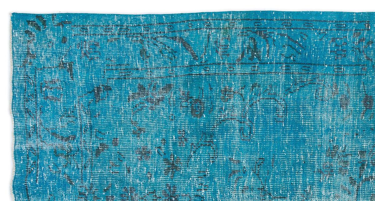 Bright turquoise rug with a distressed, faded traditional medallion pattern in dark charcoal.