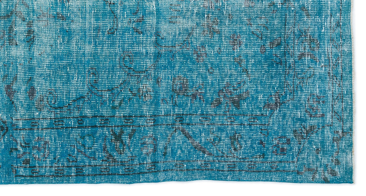 Teal and black distressed rug with a traditional ornate medallion pattern and a bordered edge.