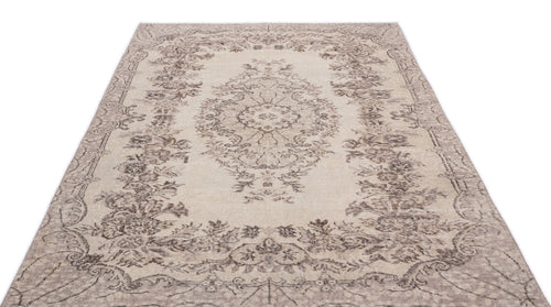 Load image 1 in gallery view. Beige and taupe distressed rug with a traditional floral medallion pattern and ornate border on a white background.