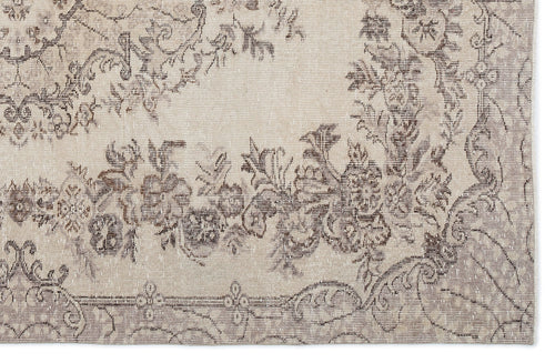 Load image 1 in gallery view. Beige and taupe distressed rug with a faded floral medallion pattern.