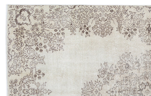 Load image 1 in gallery view. Beige and brown rug with a distressed, faded floral medallion pattern on a plain background.