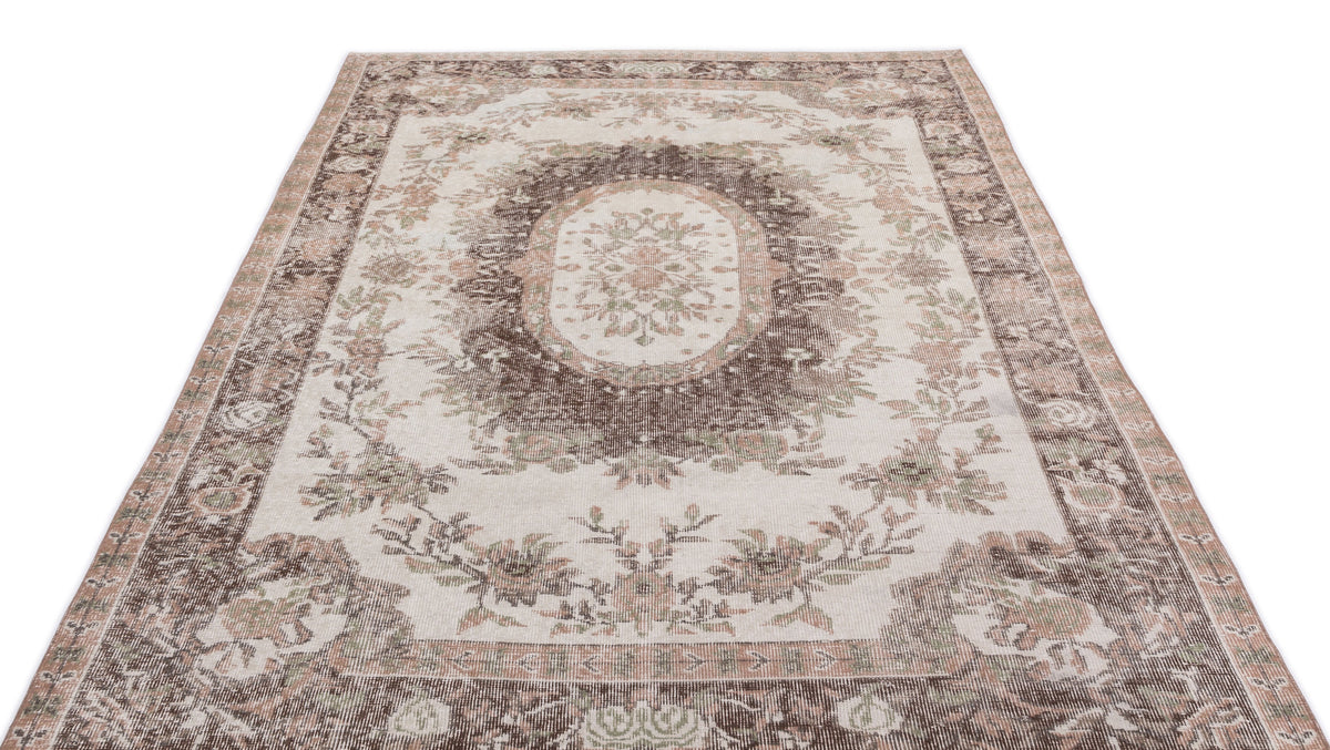 Cream, brown, and muted green vintage-style rug with a central floral medallion and ornate border on a white background.