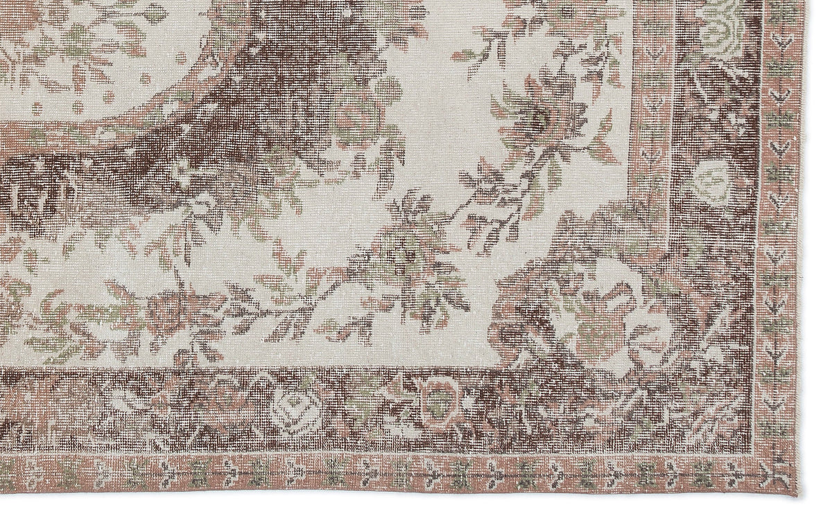 Cream, brown, and muted green vintage-style rug with a distressed floral medallion pattern and a detailed border.