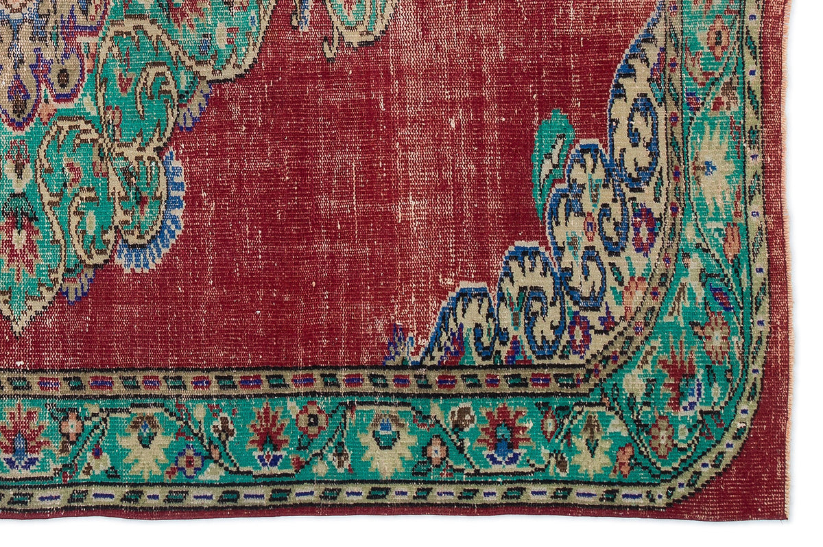 Deep red traditional rug with a distressed finish, featuring teal and beige floral medallion borders.