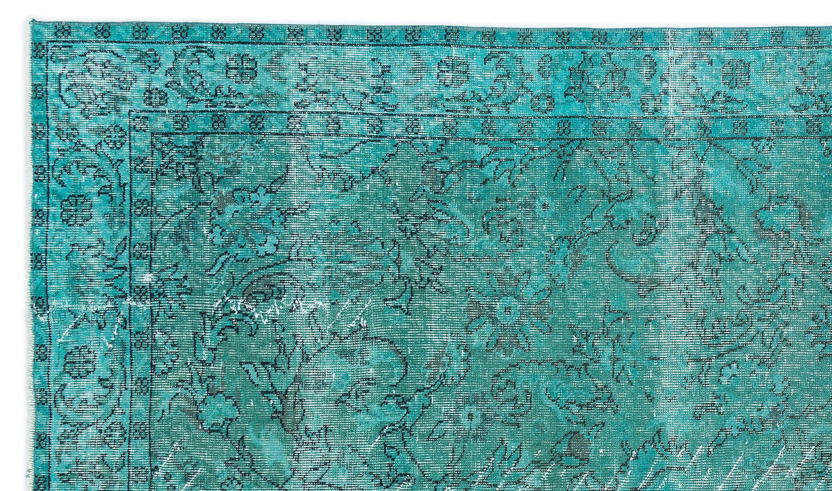 Teal and black distressed rug with a traditional floral medallion pattern and a detailed border.