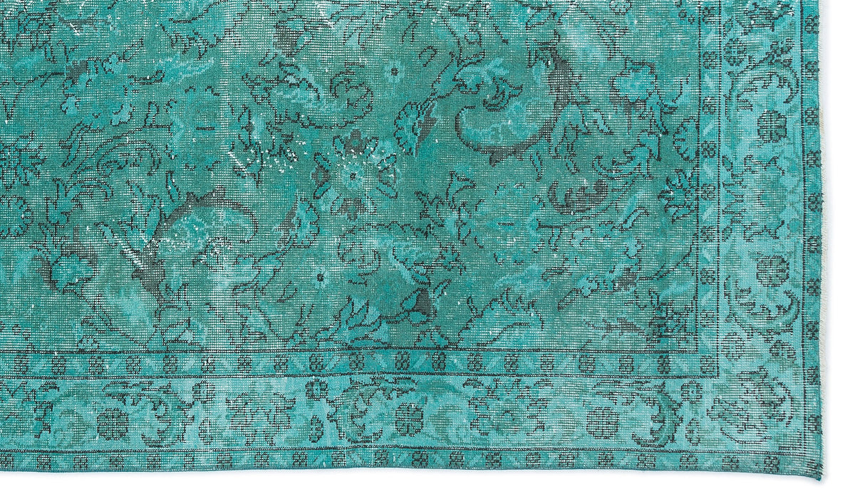 Teal and black distressed rug with a traditional floral medallion pattern and a detailed border.