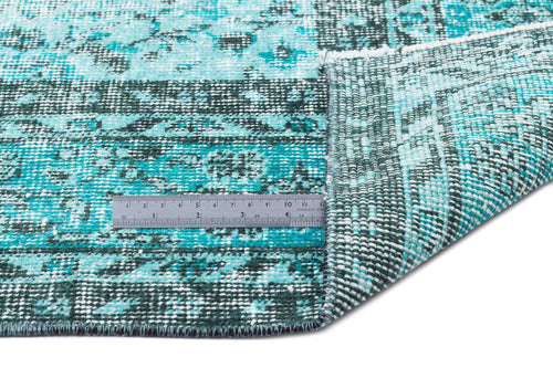 Load image 1 in gallery view. Turquoise and dark green distressed rug with a faded floral pattern, shown with a metal ruler for scale.