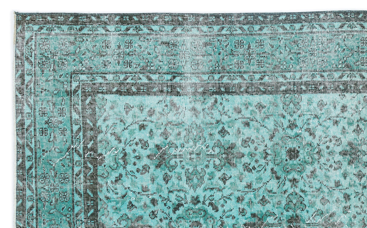Teal and charcoal distressed rug with a traditional ornate floral medallion pattern and a geometric border.