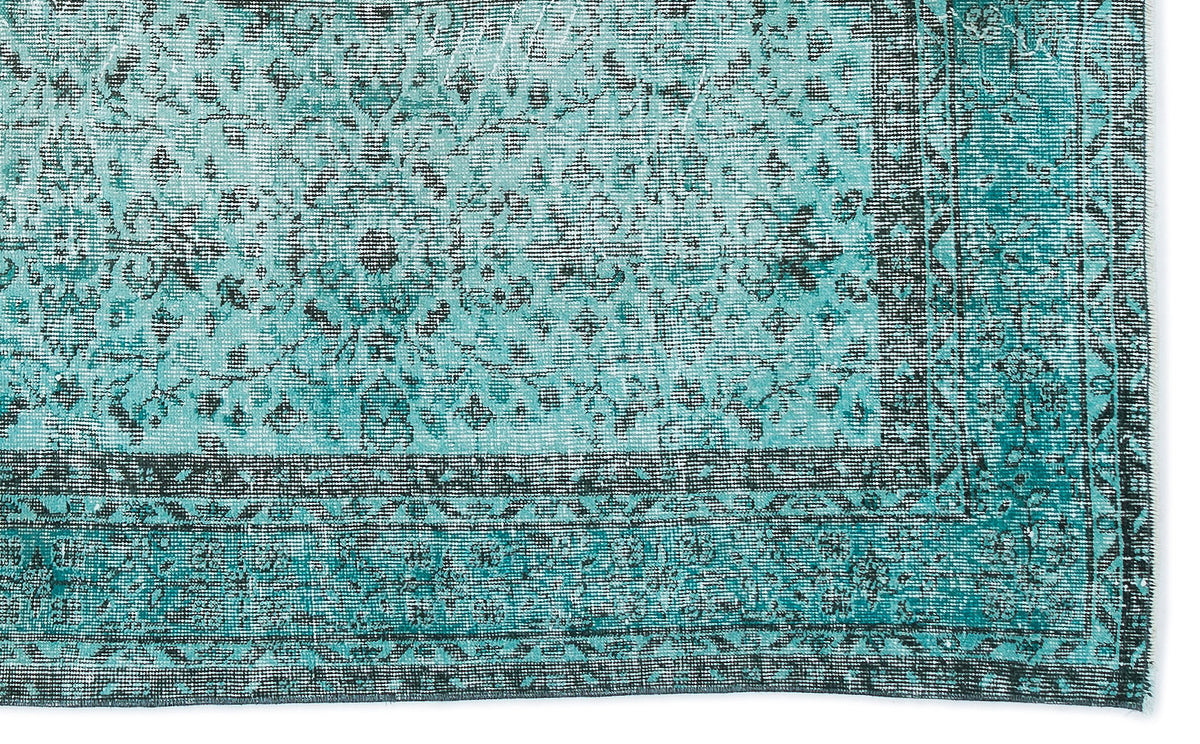 Teal and black distressed rug with a traditional floral medallion pattern and a geometric border.