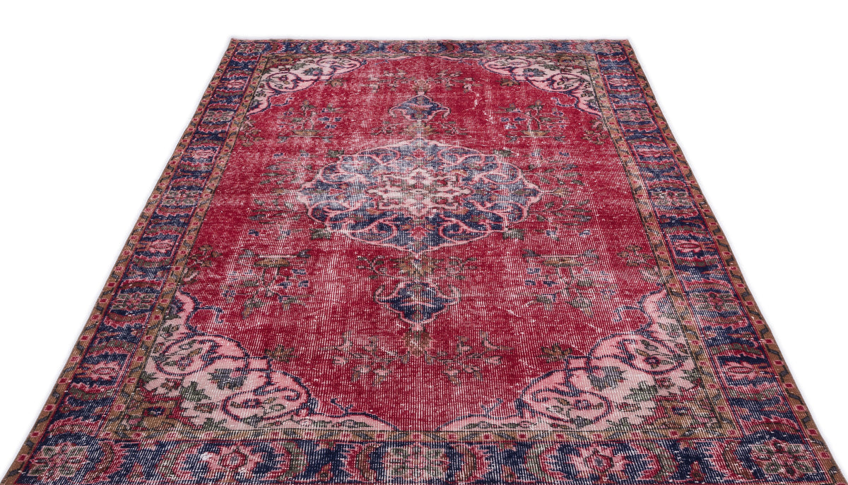Distressed red and navy blue traditional rug with a central floral medallion and ornate border on a white background.