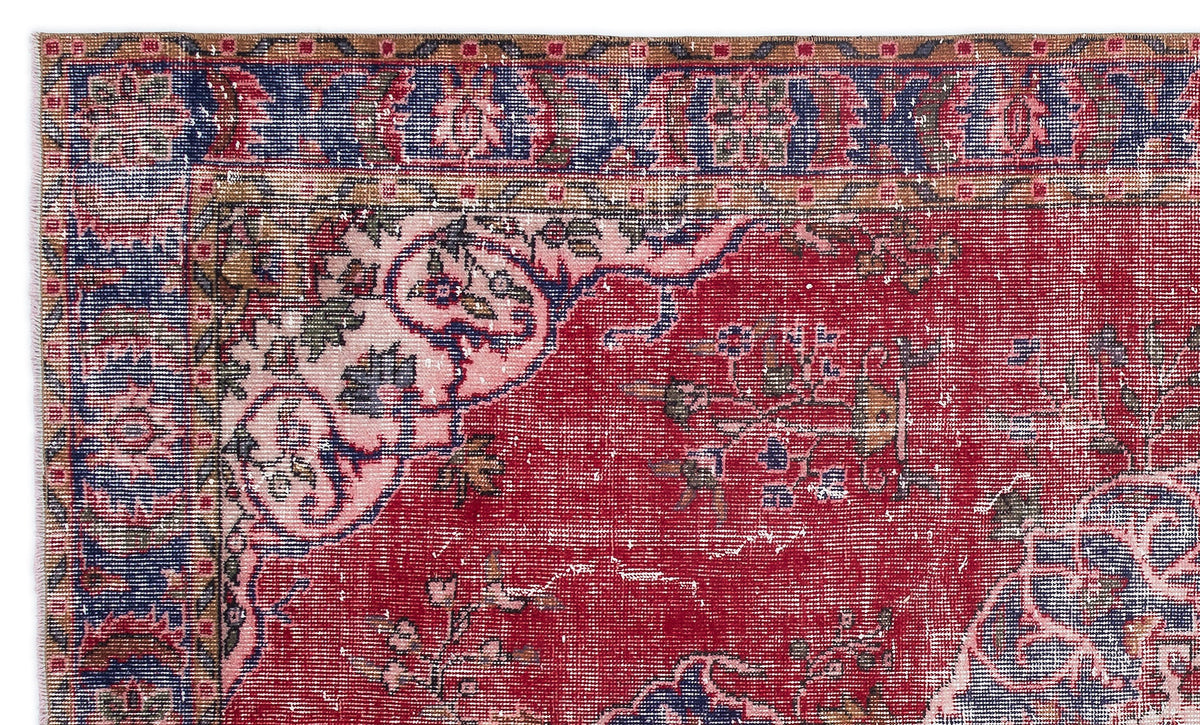 Distressed red traditional rug with a blue border and faded floral medallion pattern.