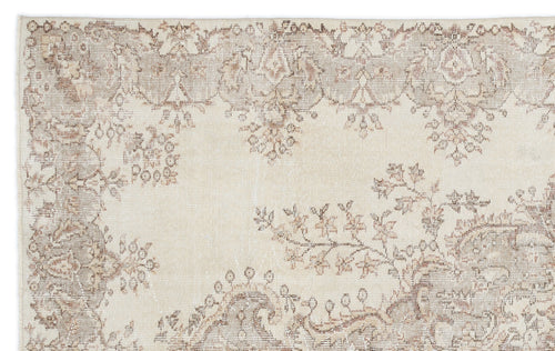 Load image 1 in gallery view. Beige and taupe vintage-style rug with a faded floral medallion pattern on a white background.