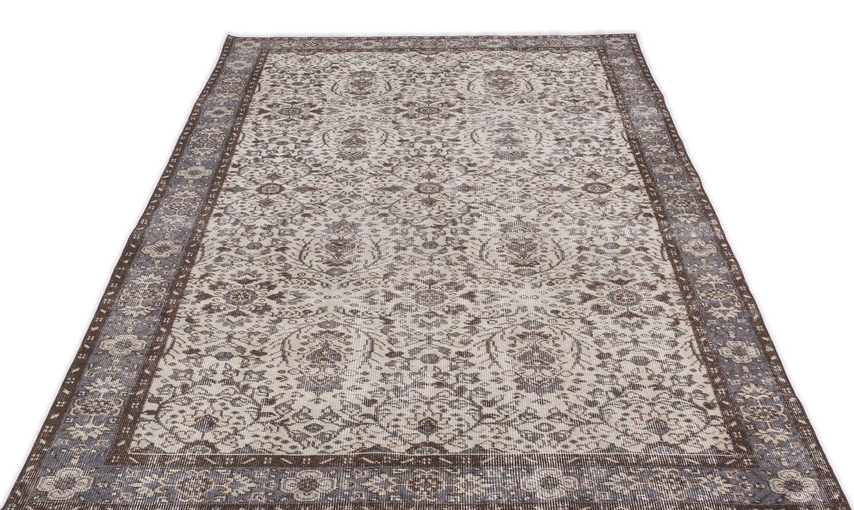Distressed brown and cream area rug with a traditional floral medallion pattern and a wide decorative border.