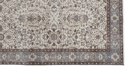 Load image 1 in gallery view. Cream, brown, and slate blue rug with a traditional floral medallion pattern and a detailed geometric border.