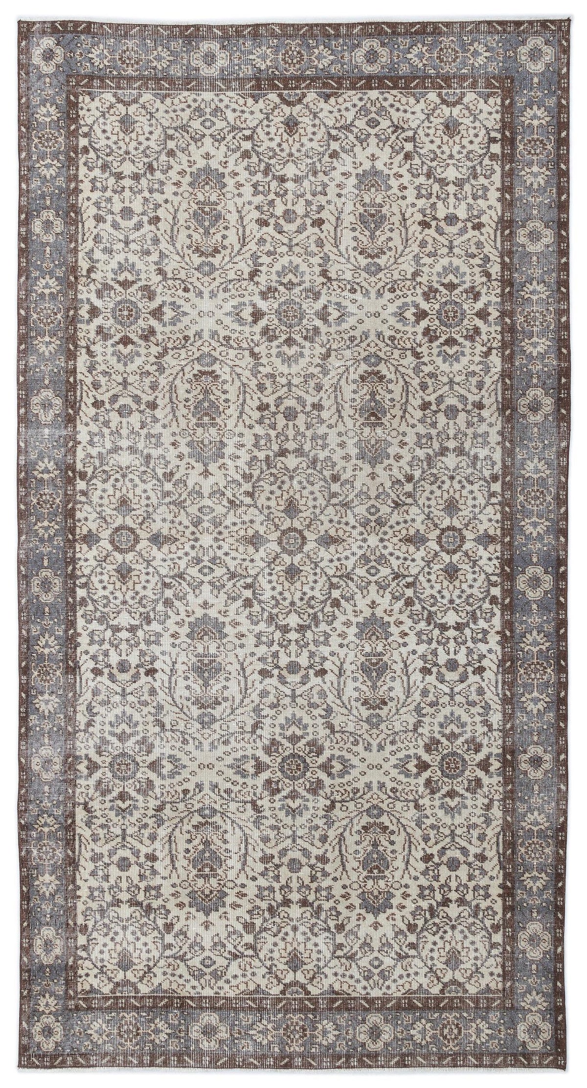 Cream, brown, and slate blue traditional rug with a distressed floral medallion pattern and a wide decorative border.