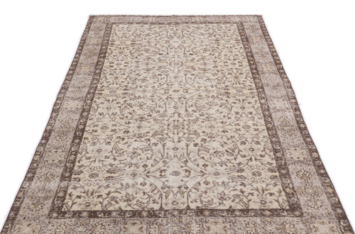 Load image 1 in gallery view. Beige and brown vintage-style rug with a distressed floral medallion pattern and a wide decorative border.