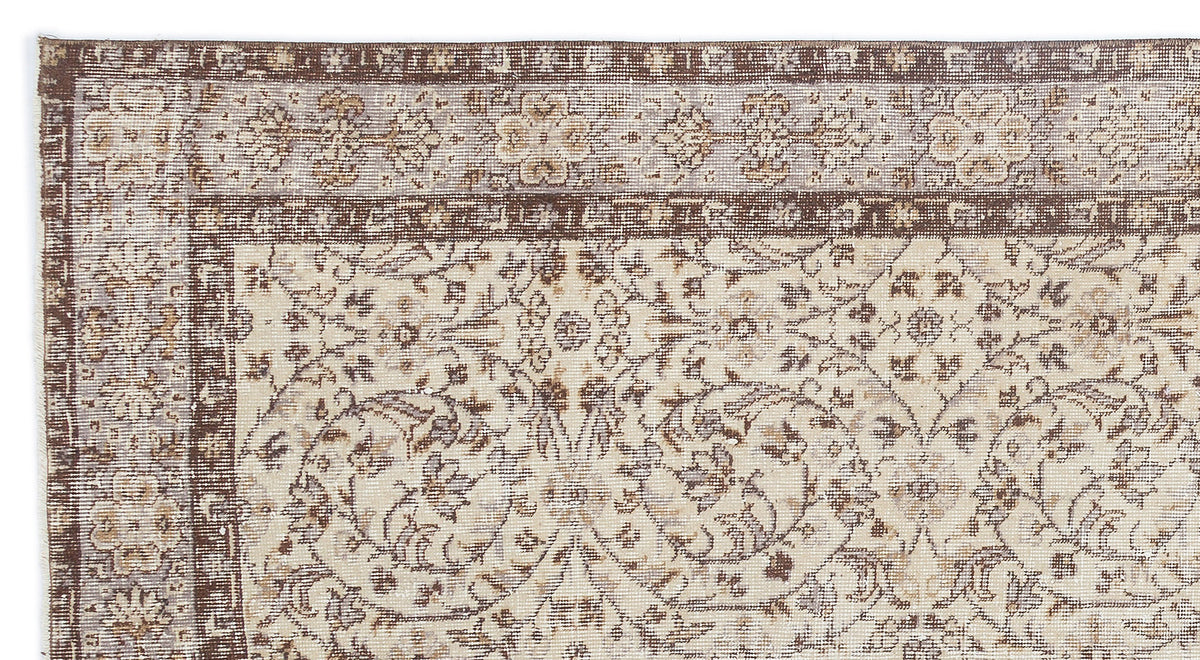 Beige and brown vintage-style rug with a distressed floral medallion pattern and a detailed decorative border.