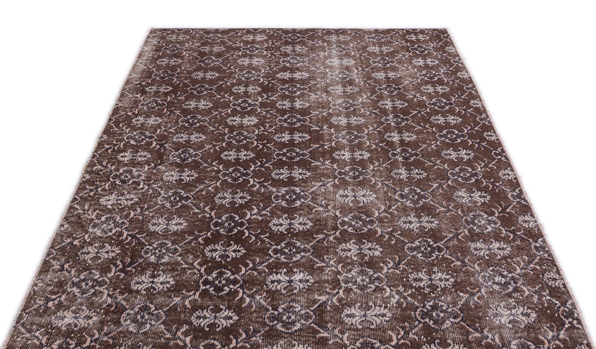 Dark brown vintage-style rug with a repeating cream and charcoal floral trellis pattern on a white background.