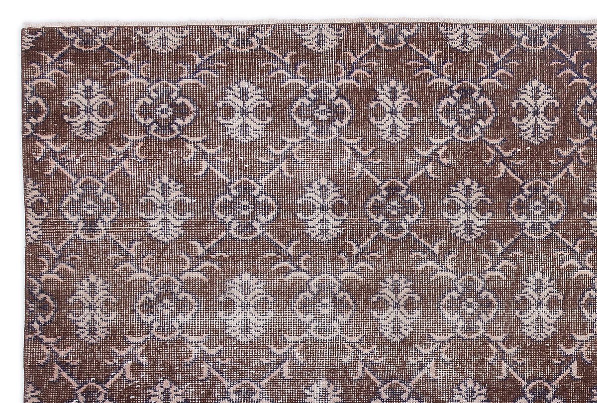 Dark brown rug with a repeating light blue floral medallion and lattice pattern.