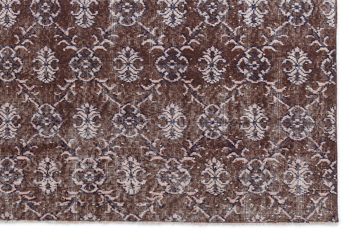 Load image 1 in gallery view. Dark brown rug with a repeating light pink and cream floral medallion pattern in a distressed, vintage style.