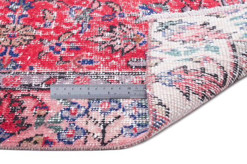 Load image 1 in gallery view. Red and pink traditional floral rug with a folded corner revealing the backing and a metal ruler for scale.