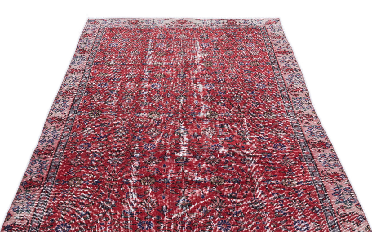 Red vintage-style rug with a distressed floral pattern and faded blue and cream accents on a white background.