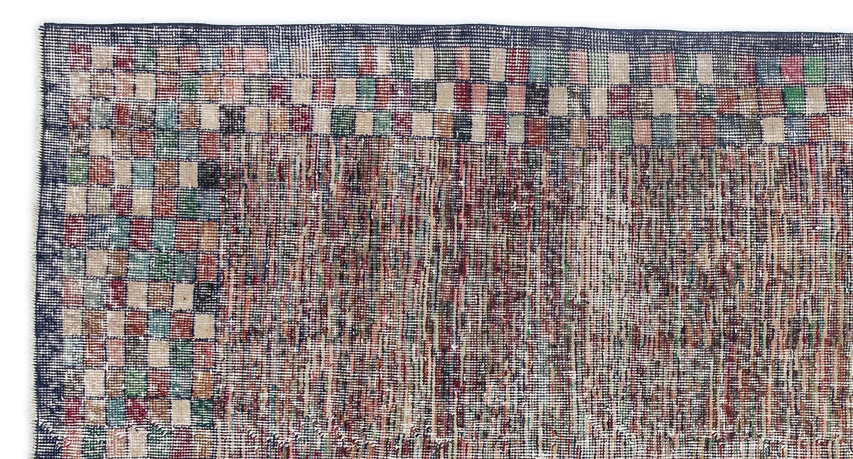 Distressed multi-colored rug with a checkered border and a textured, variegated center field.