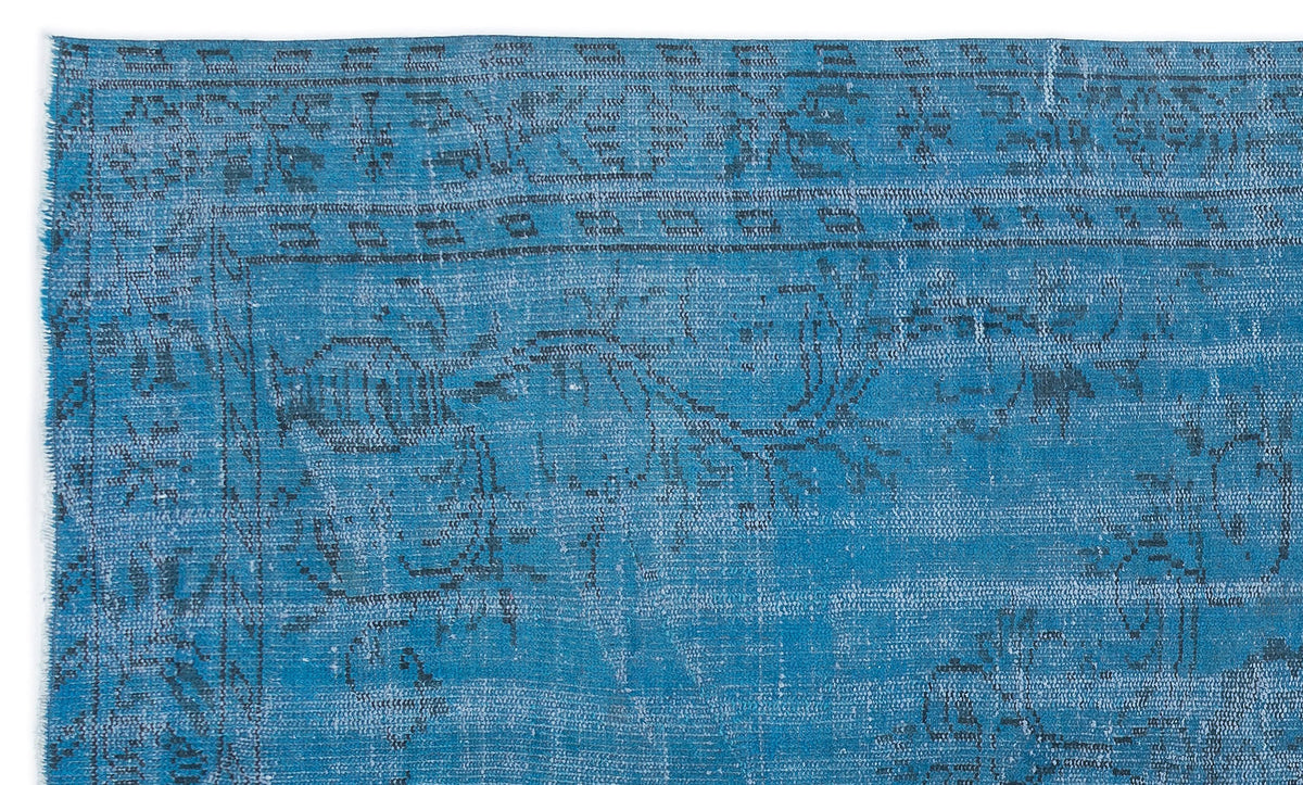 Bright blue distressed rug with a faded charcoal grey traditional medallion pattern on a white background.