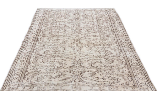 Load image 1 in gallery view. Cream and brown area rug with a distressed traditional floral medallion pattern and a decorative border.