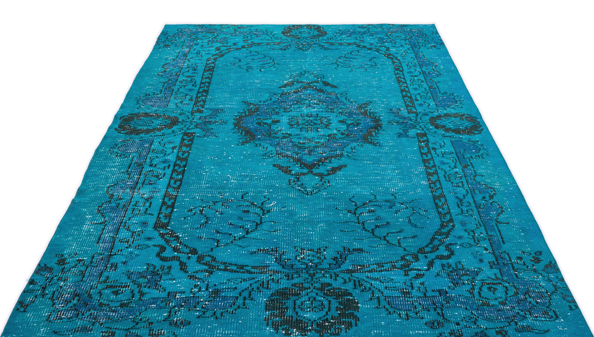 Turquoise and navy blue distressed rug with a traditional central medallion and ornate border pattern.