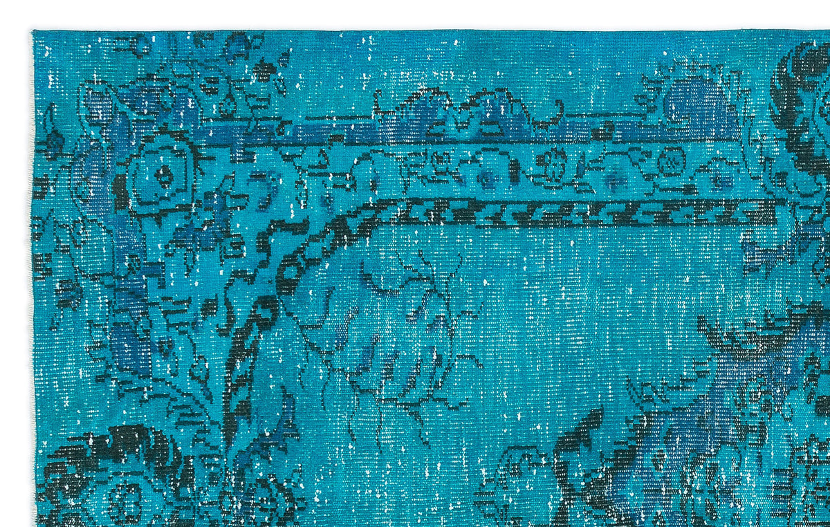 Bright turquoise and navy blue distressed rug with a traditional ornate medallion pattern.