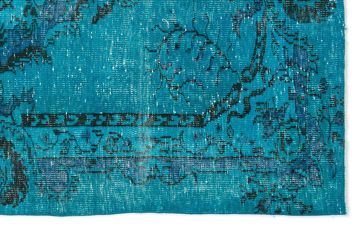 Teal and blue distressed rug with a traditional black floral medallion pattern and a geometric border.