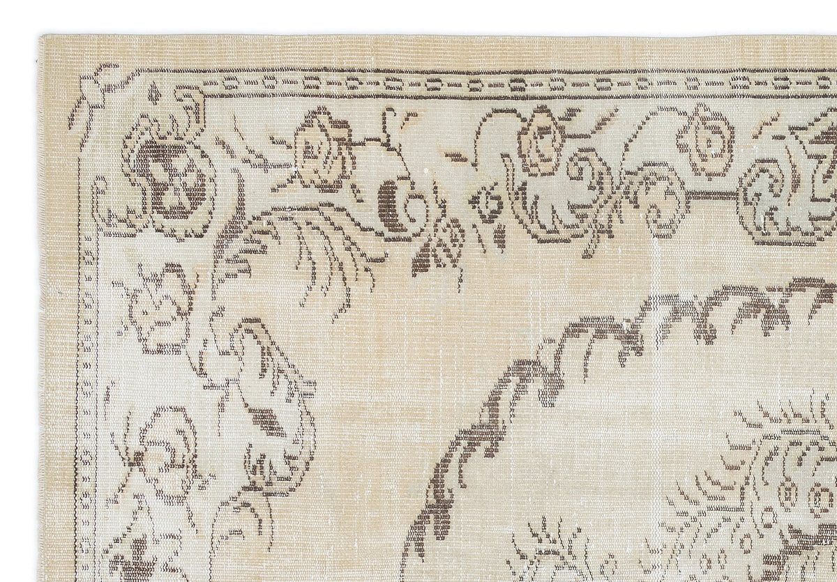 Beige rug with a dark brown floral medallion pattern and a decorative border.