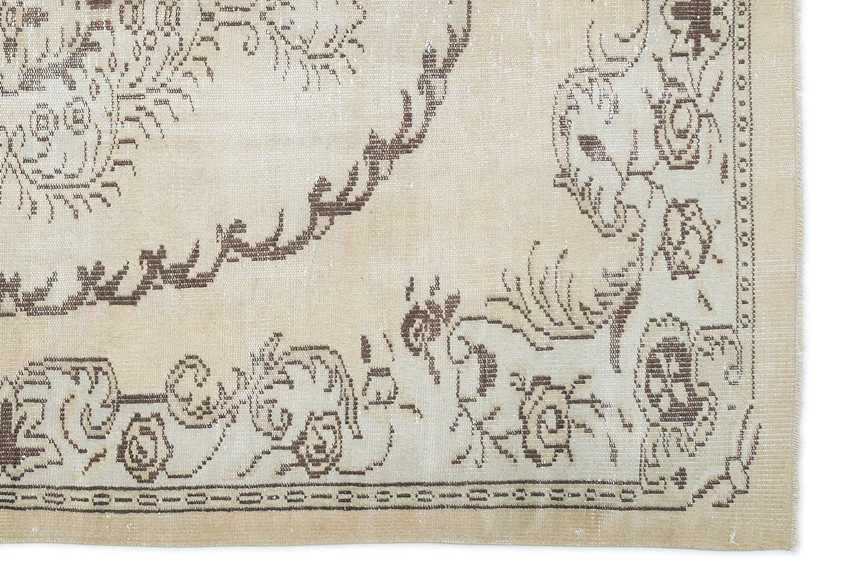 Beige and brown rug with a distressed traditional floral medallion pattern and a decorative border.