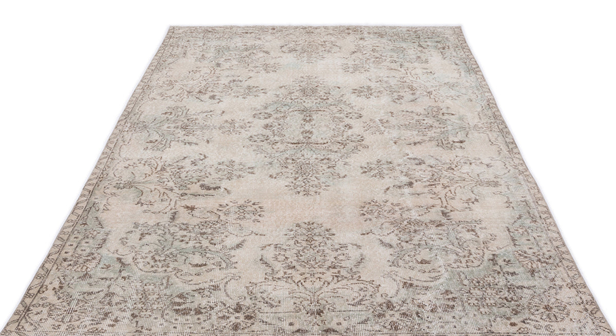 Beige and grey distressed area rug with a faded traditional floral medallion pattern on a white background.