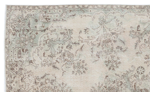 Load image 1 in gallery view. Beige and sage green rug with a distressed, faded floral medallion pattern on a white background.