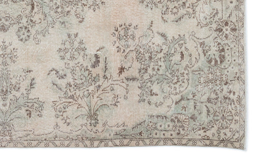 Load image 1 in gallery view. Beige and sage green vintage-style rug with a distressed floral medallion pattern.