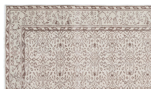 Load image 1 in gallery view. Beige and brown flatweave rug with a traditional floral vine pattern and geometric border on a white background.