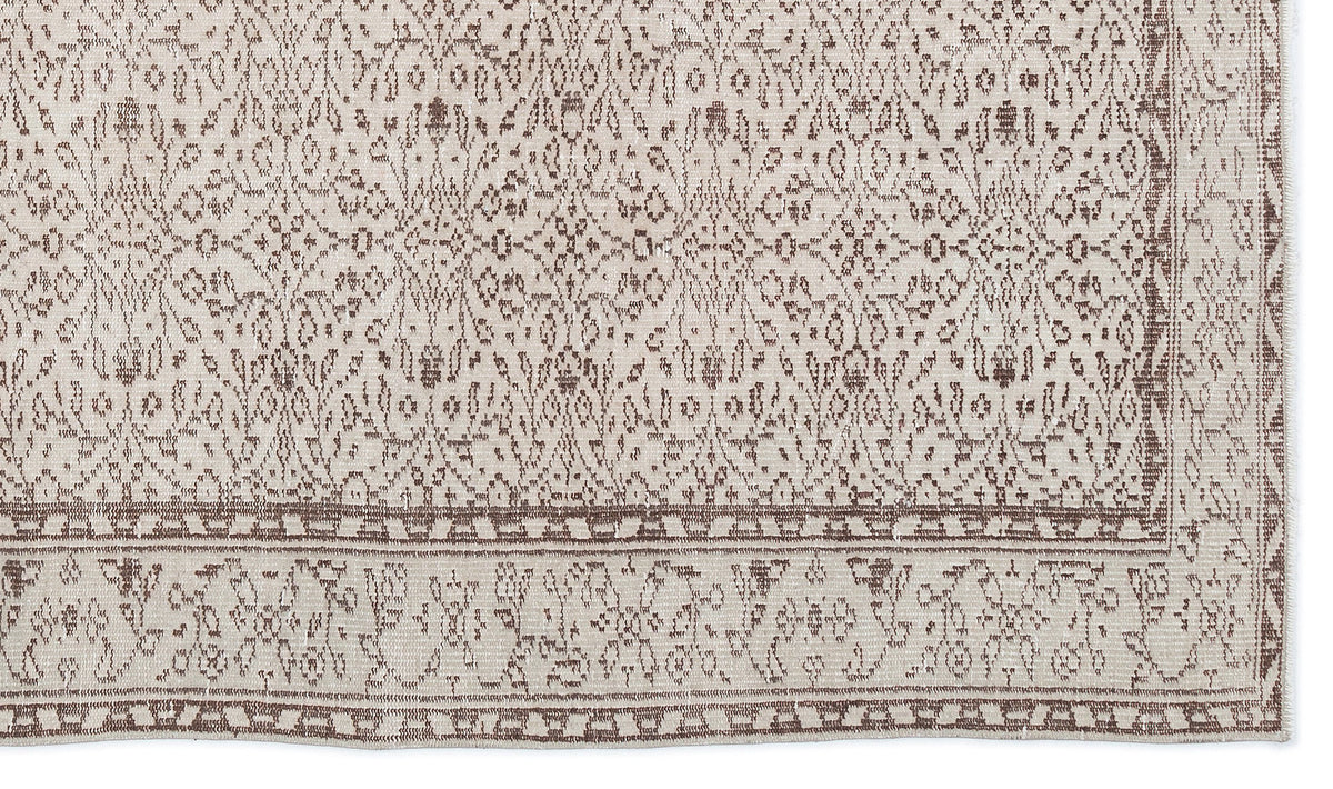 Beige and brown rug with a traditional distressed floral pattern and a detailed border.
