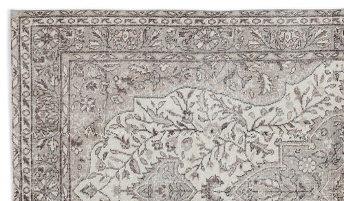 Load image 1 in gallery view. Taupe and cream vintage-style rug with a distressed floral medallion pattern and a detailed geometric border.