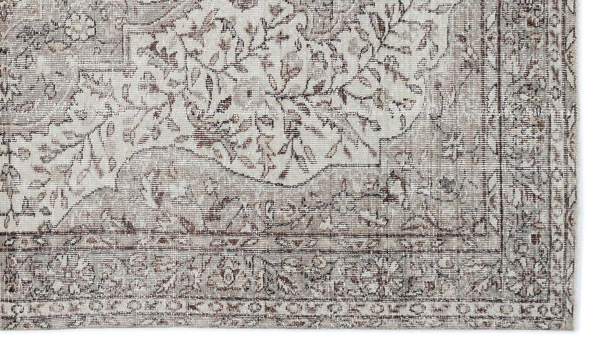 Taupe and cream rug with a distressed traditional floral medallion pattern and a detailed border.