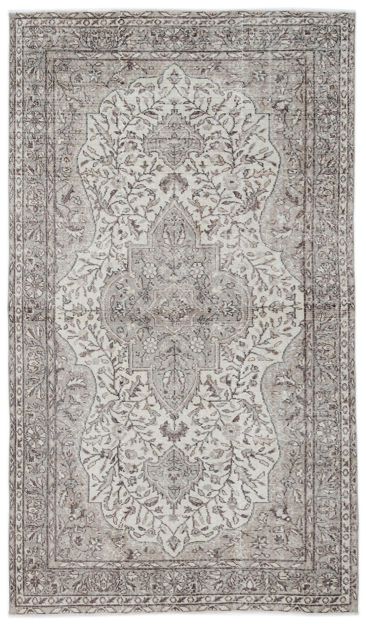 Taupe and cream distressed area rug with a central floral medallion and ornate border pattern.