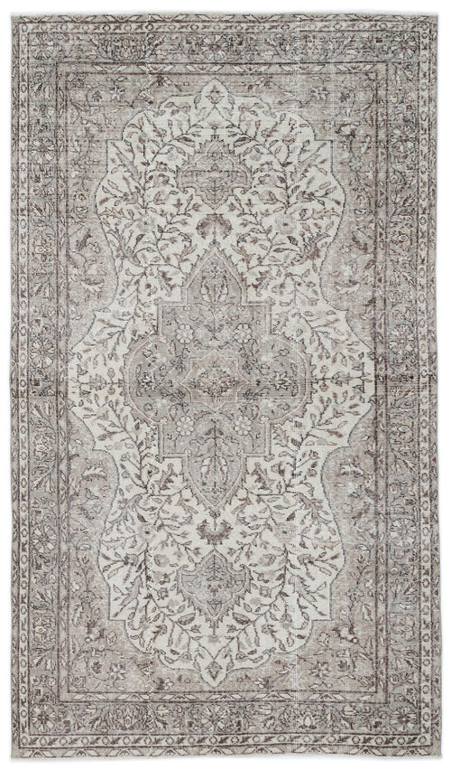 Load image 1 in gallery view. Taupe and cream distressed area rug with a central floral medallion and ornate border pattern.
