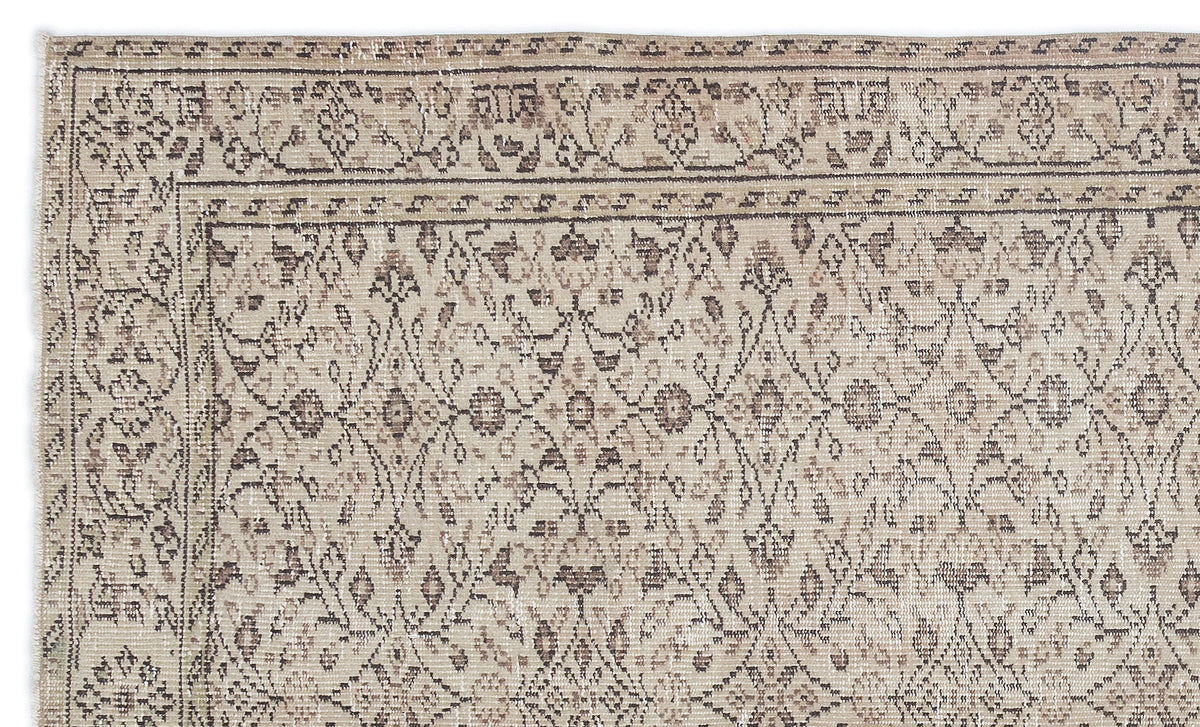 Beige and brown distressed rug with a traditional floral trellis pattern and a decorative border.