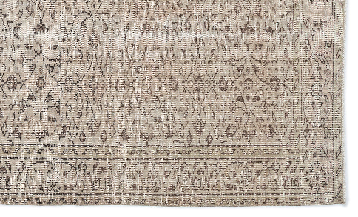 Beige and taupe distressed rug with a traditional floral medallion pattern and a detailed border.